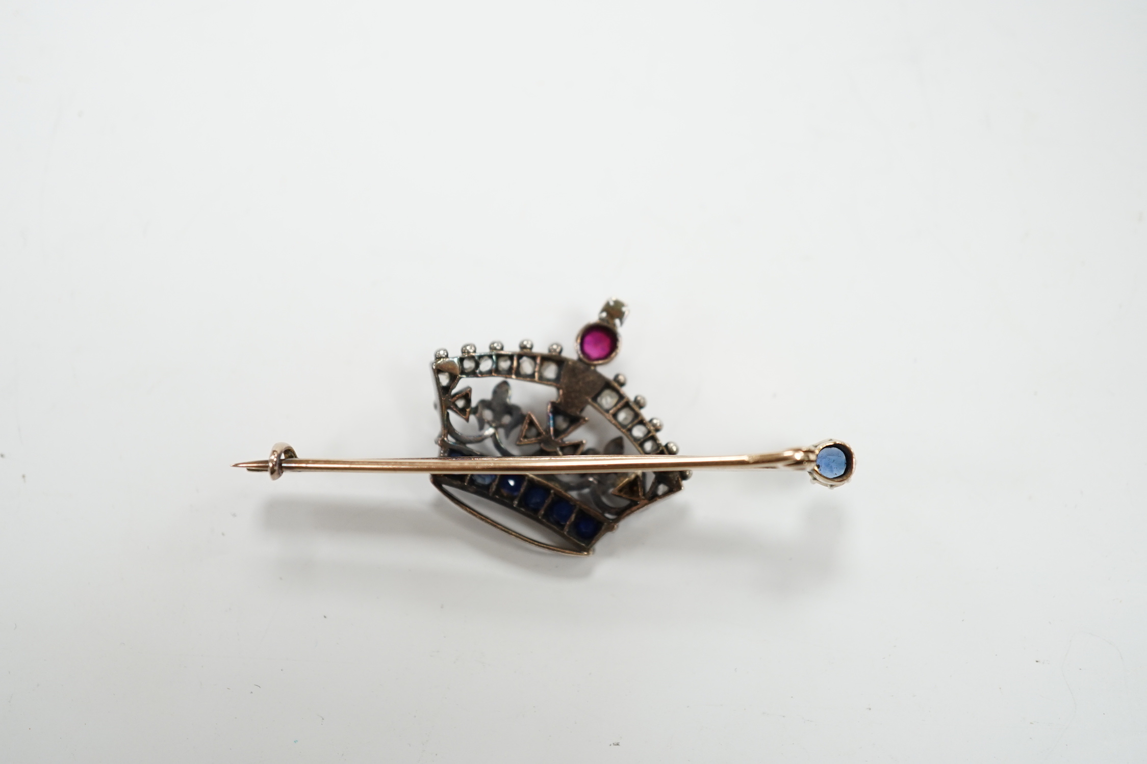 An Edwardian yellow metal, ruby, sapphire and rose cut diamond set coronet bar brooch, 50mm, gross weight 5.8 grams.